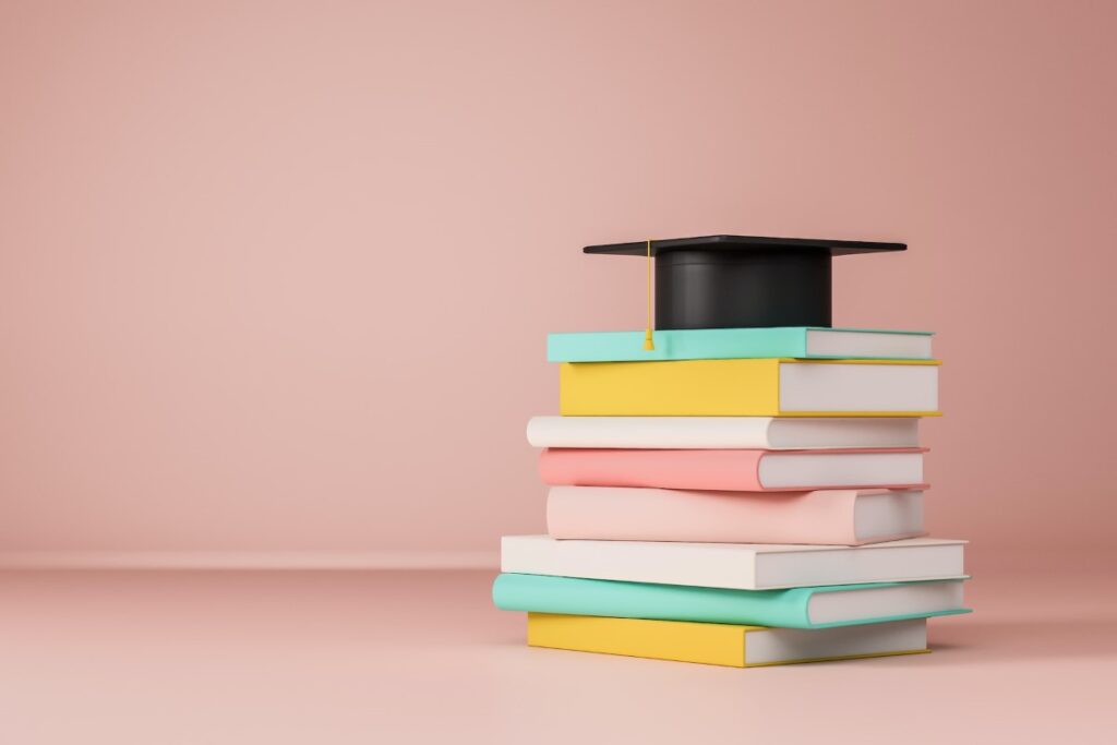 Graduate cap on a stack of books representing graduate classes